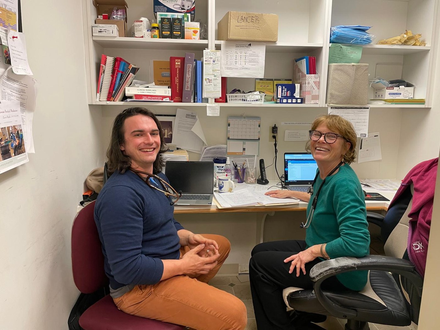 Two volunteers smiling in the clinic office